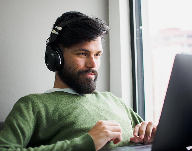 Flexible Universal Life Insurance - Man wearing headphones while working on computer | Photo by Miguelangel Miquelena on Unsplash
